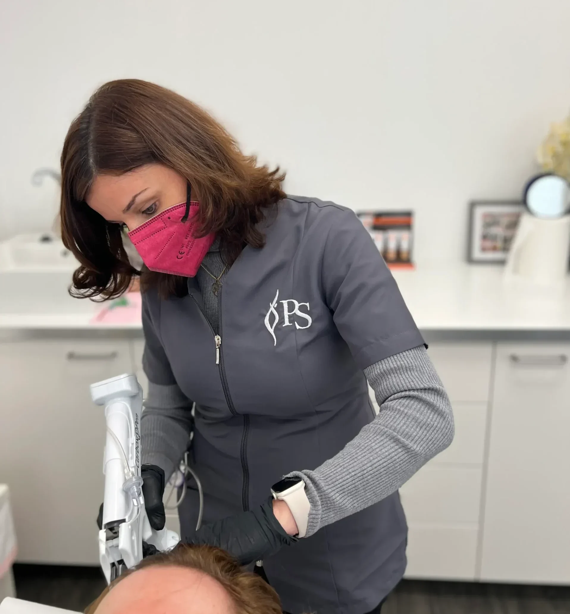 Doctora realizando tratamiento capilar en paciente